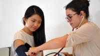 Q clinic staff checking blood pressure of a patient